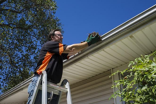 worker repairing gutters on a house in Alden, NY